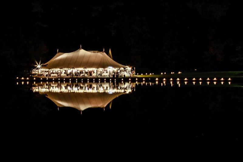 Wedding By Martha - A tent lit up accorss a pond for a wedding cerimony - wedding photography